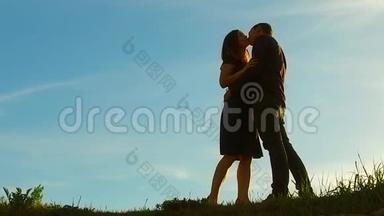 日落时分一对夫妇的<strong>剪影</strong>。 男人和女人的<strong>剪影</strong>在夕阳下缓慢的运动。 日出时情侣接吻
